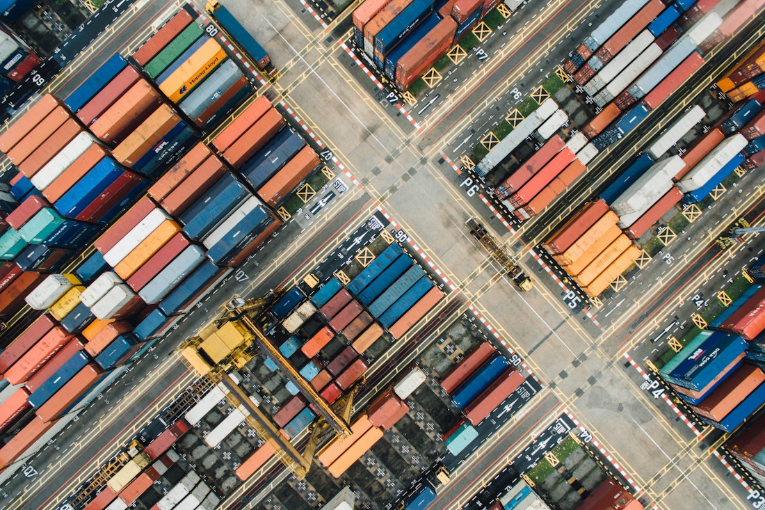 Vista aérea de contenedores apilados en una terminal portuaria